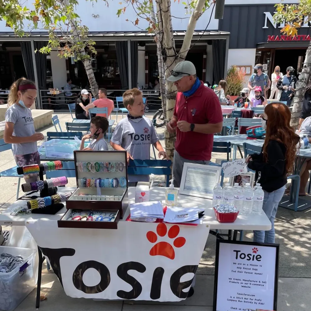 The first sale, the table under the hand painted Tosie banner with the red paw print across the front